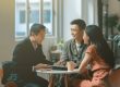 Asian couple discussing with property agent on their first home purchase