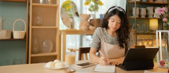 HLAS-blog-hospital-income-masthead-min-img1 Asian woman working on her laptop and notebook at a cafe